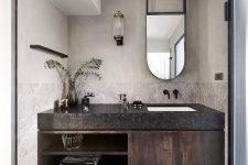 10 There’s a floating vanity with a black countertop and some greenery