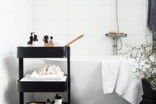 10 a black IKEA cart used for storage in a Scandinavian bathroom is a stylish piece to try