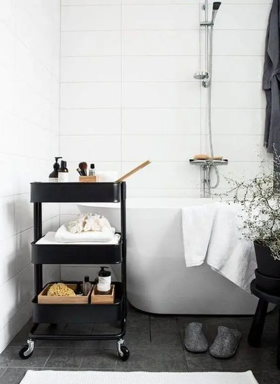 a black IKEA cart used for storage in a Scandinavian bathroom is a stylish piece to try