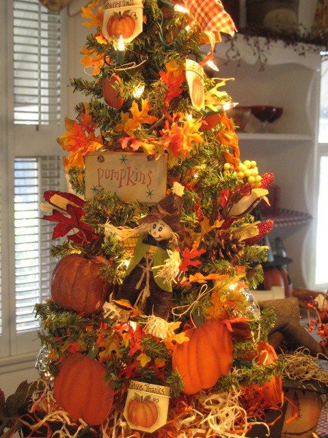 A creative vintage inspired Thanksgiving tree with lights, faux leaves, pumpkins, signs, paper pumpkins