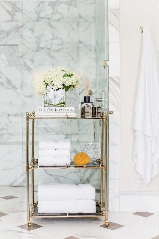 a refined gold and glass rolling cart is a gorgeous option for a sophisticated and chic bathroom