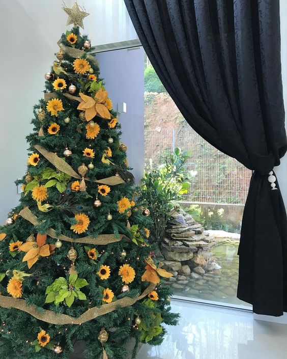 a stylish rustic Thanksgiving tree decorated with gold mesh ribbons, faux sunflowers, bright greenery and gold ornaments
