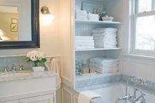 19 a cabinet with open shelves placed over the tub is a stylish storage unit you may rock