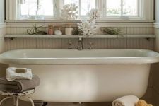 21 a shabby chic coastal bathroom with an open floating shelf over the tub that allows displaying decor