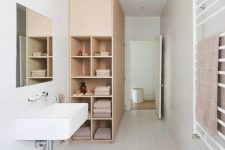 23 a neutral minimalist bathroom showing off a large cabinet for storage that ends up with open shelving for more comfort