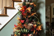 25 a vintage rustic tree with faux pumpkins, leaves, branches, berries on top and a faux owl is bold