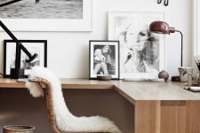 a Scandinavian home office nook with a floating corner desk, a gallery wall, a rattan chair and a basket plus some faux fur