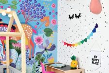 a beautiful and bold kid’s room with a bright paitned wall, faux taxidermy, bold garlands and toys and a hot pink chair