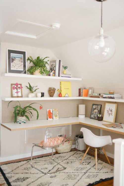a bright shared contemporary home office with a corner desk and matching shelves, bright accessories and mismatching chairs