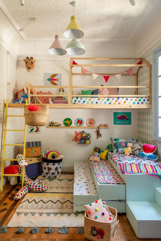 a colorful kid's room with bright bedding, rugs, pillows and blankets and pastel pendant lamps