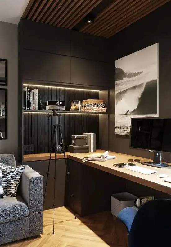 A contemporary moody home office with closed and open storage units, built in lights, a large desk and upholstered chairs
