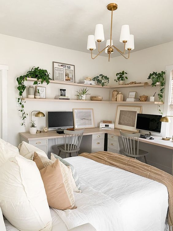 A lovely boho bedroom with a double working space, an L shaped desk, grey chairs and corner shelves is amazing