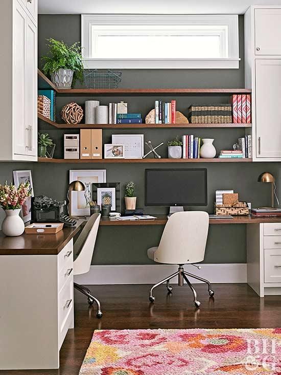 A mid century modern home office with a black wall, a corner desk and open shelves with closed storage units plus chic white chairs