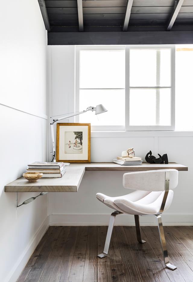 a minimalist home office nook with a floating corner desk, a whimsical chair and books and a stylish industrial lamp