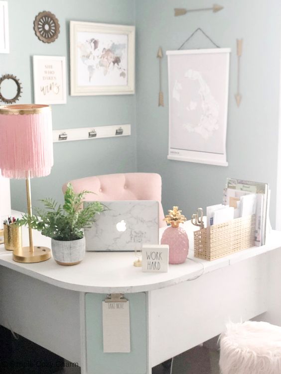 a pastel girlish home office with a curved corner desk, pink accessories and a pink chair and gold touches for more chic