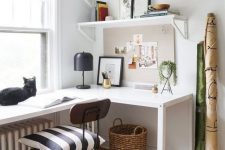 a stylish mid-century modern home office with a white corner desk, a black industrial chair and open shelves is chic