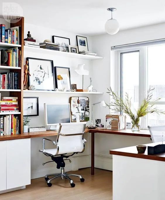 A stylish modern home office with an L shaped desk, a white chair, open shelves and bookshelves is a comfortable working space
