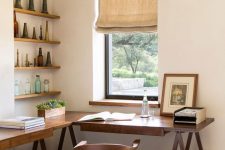 a stylish work nook with an L-shaped trestle desk, a stained chair, open shelves and decor, a burlap curtain