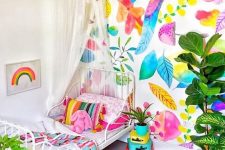 a super bright kid’s room with a colorful botanical wall, bright bedding and a rug, colorful mini suitcases and a hot pink planter