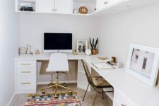 a white boho home office with an L-shaped desk with storage, kitchen cabinets for storage, a bold rug and mismatching chairs