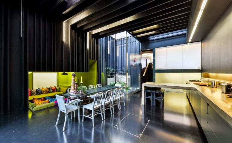 The dining-kitchen zone is done with a sunken conversation pit with lime green walls and bright pillows
