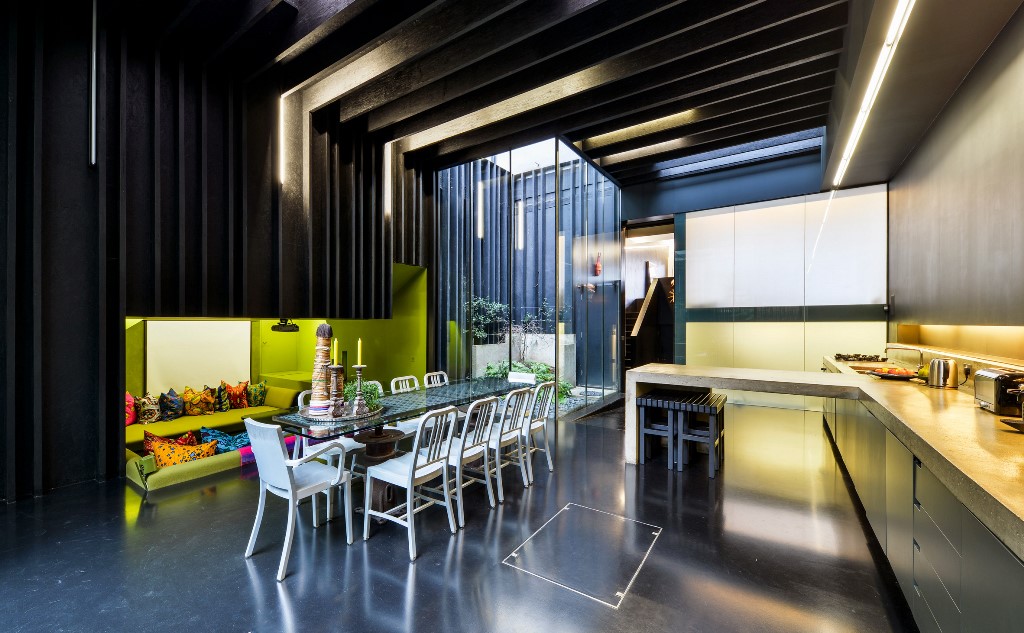 The dining kitchen zone is done with a sunken conversation pit with lime green walls and bright pillows