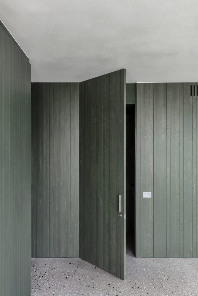 The same green stain has been applied across the apartment's wood panelled walls