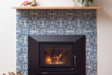 03 a built-in fireplace surrounded with blue printed tiles and navy ones looks ultimately chic and very elegant