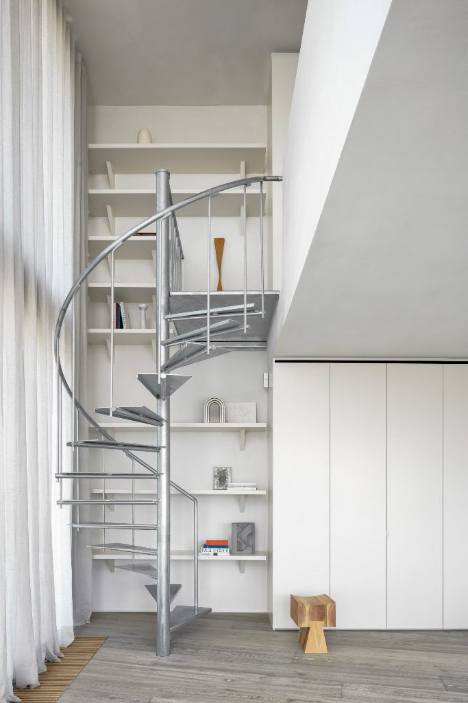 A galvanised-steel staircase connects the apartment's two floors and here you may see white to refresh the space