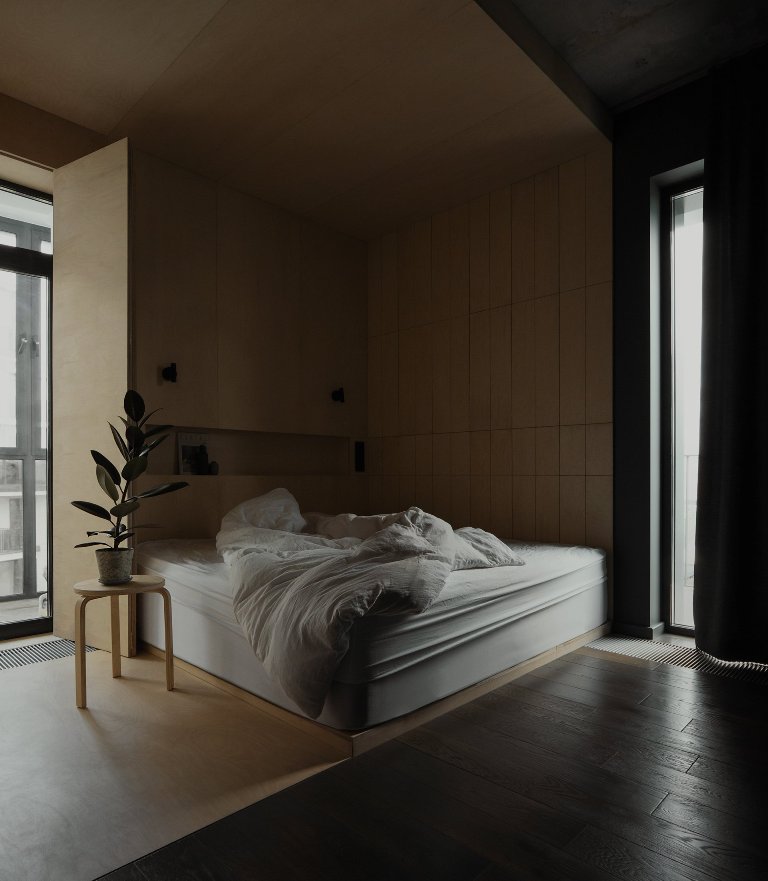 The sleeping zone is clad with light-colored plywood, there's built-in storage and a comfy bed