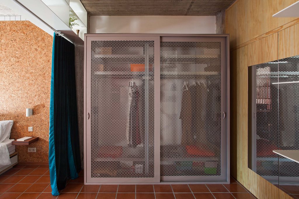 The wardrobe is industrial, with wire doors that are slightly sheer