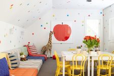 08 a fun and bold kids’ playroom with sofas lining up the wall, a creativity zone, polka dot walls and a ceiling and bright toys