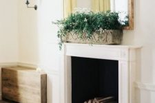 08 a vintage and refined fireplace with a white mantel and firewood inside plus a planter with greenery and blooms for a chic space