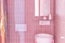 09 There’s also another bathroom clad with pink tiles, a round sink and an arched mirror plus a shower space