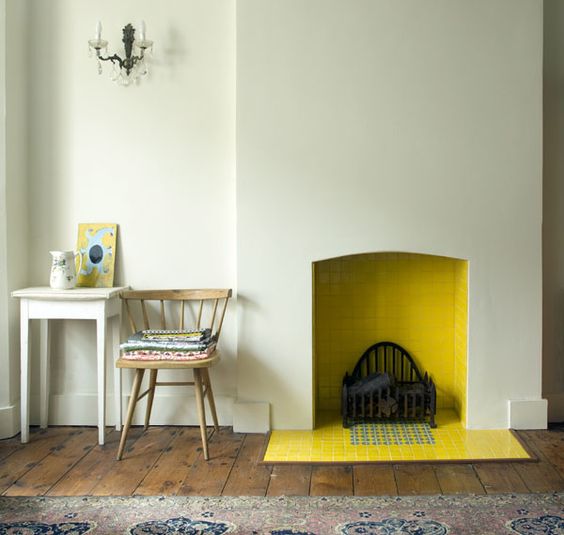 a minimalist fireplace with yellow tiles inside and out brings a warm feeling to the space and adds a bright splash of color