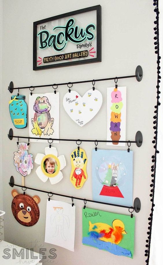 a bold kids' artwork display with railings is a stylish and cool idea and you may add more and more works there