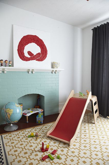 A non working mint blue brick fireplace finishes off the playroom making it cozier and more welcoming