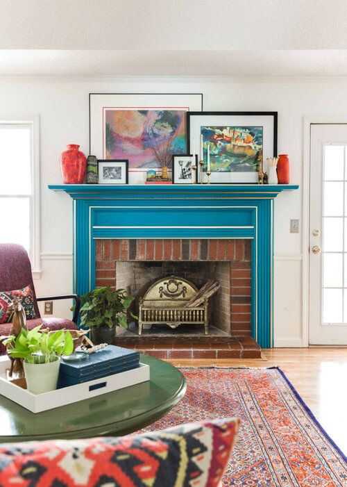 A bright mid century modern living room with a bold blue mantel with white framing over a brick fireplace for ultimate elegance