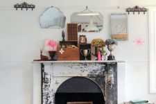 18 a shabby cihc fireplace with books and a bold artwork looks statement-like and bold, a suitcase in front of it adds vintage charm