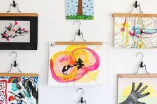19 a bold gallery wall with lots of kids’ artworks hanging is a creative and chic idea to try