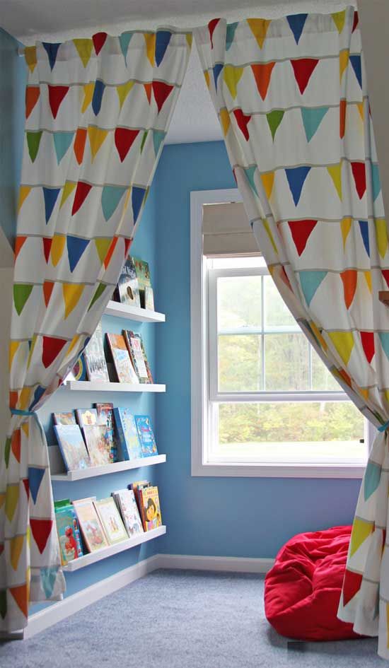 a colorful reading nook with a bright seat by the window and ledges on the wall is separated with colorful curtains