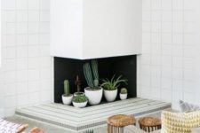 a corner fireplace with potted cacti and planters is a lovely solution for a mid-century modern space