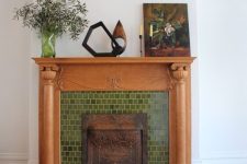 a fireplace clad with green tiles, with a stained mantel and some chic vintage decor is a lovely idea for a living room