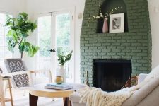a green brick fireplace with a niche for art looks out of the box and adds color to this neutral living room