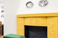a large fireplace with a yellow carved mantel, bold green acrylic stools with book storage