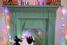 a light yellow mantel and a non-workign fireplace, toy decor on the mantel and some lights for a kids’ room