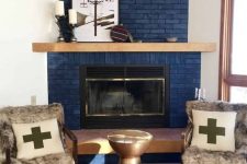 a modern space wiht a navy brick fireplace, a boho rug, a metal sid etable and upholstered chairs with faux fur
