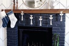 a navy brick fireplace with a wooden mantel and some metallic chess inside is a very fresh take on a traditional piece