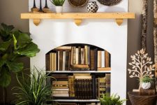a non-working fireplace as a bookcase, with lots of books and lights, with boho baskets and candles on the mantel