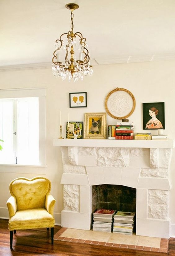 A non working fireplace with books inside, with books on the mantel, some artwork and candles is lovely